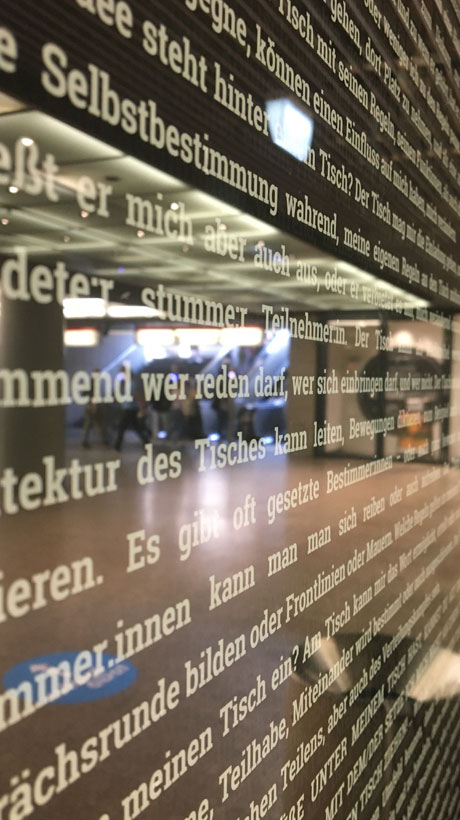 Ausstellungsbeschriftung auf einer Glaswand in einer Ausstellung in Düsseldorf