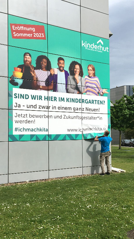 Großformatige Beschriftung einer Unternehmensfassade für eine Kita in Düsseldorf